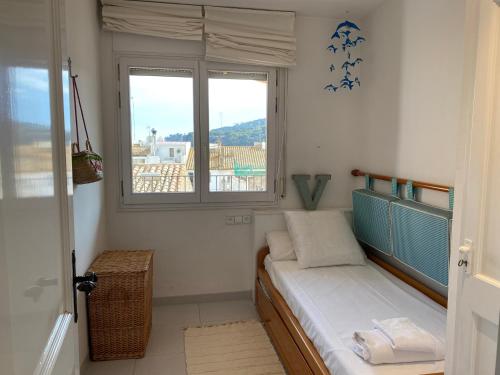 a small room with a bed and two windows at BLAU Bonito Duplex con Terraza in Calella de Palafrugell