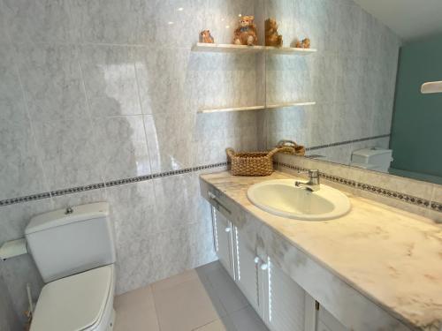 a bathroom with a sink and a toilet at BLAU Bonito Duplex con Terraza in Calella de Palafrugell