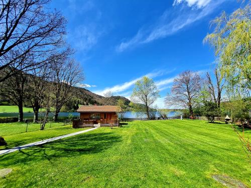 a building in a field with a grassy field at Appartementhaus „die Kuh am See“ (vormals Haus St. Leonhard) in Schliersee