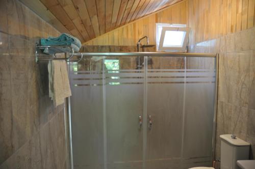 um chuveiro com uma porta de vidro na casa de banho em Bellerofon Beach Otel em Cirali