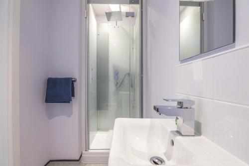 a white bathroom with a sink and a shower at No 2 Ocean Cabins - Saundersfoot Harbour - Saundersfoot in Saundersfoot