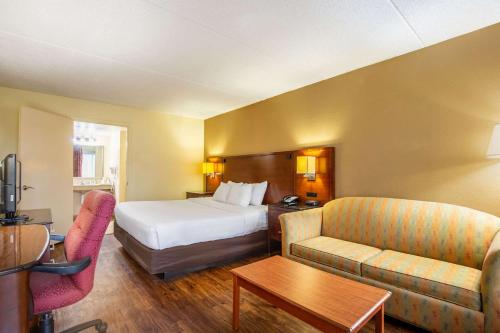 ノーフォークにあるEcono Lodge Naval Station Norfolkのベッドとソファのあるホテルの部屋
