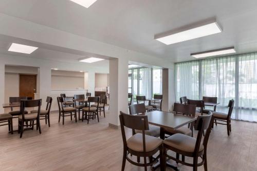 a dining room with tables and chairs and windows at Quality Inn Saint Petersburg North-Tampa Bay in St Petersburg