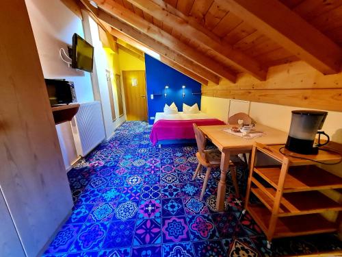 a room with a bed and a table in a room at Appartementhaus „die Kuh am See“ (vormals Haus St. Leonhard) in Schliersee
