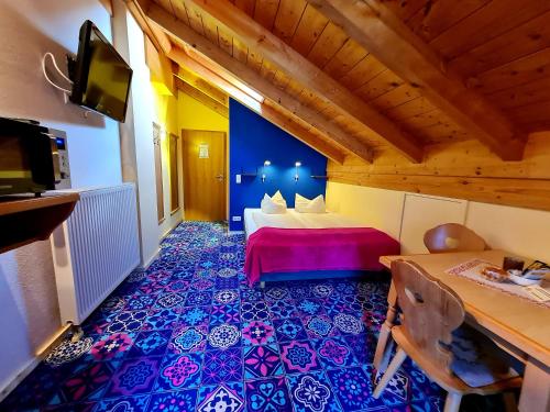 a room with a bed and a tv in a room at Appartementhaus „die Kuh am See“ (vormals Haus St. Leonhard) in Schliersee