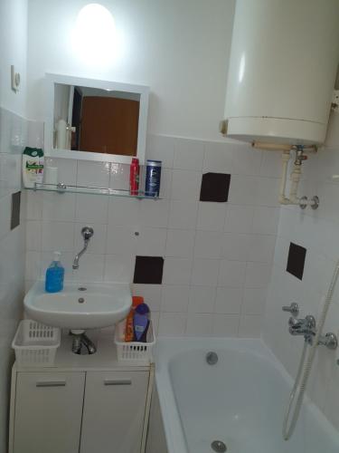 y baño con lavabo, bañera, aseo y lavamanos. en Studio apartman BF en Slavonski Brod