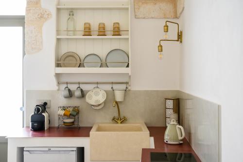 a kitchen with a sink and a counter at Cementine Traditional Suites by Wonderful Italy in Ostuni