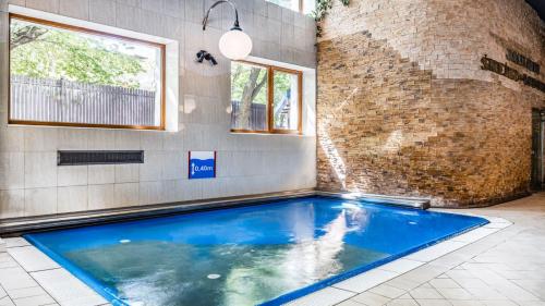 a swimming pool in a room with a brick wall at Hotel Gołębiewski Białystok in Białystok
