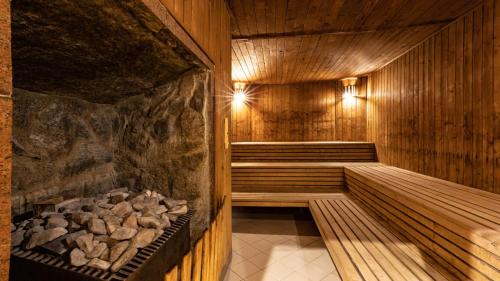 a wooden sauna with a pile of rocks in it at Hotel Gołębiewski Białystok in Białystok