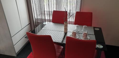 a room with a table with red chairs and a tableasteryasteryasteryasteryastery at Penzion Miromar in Podivín