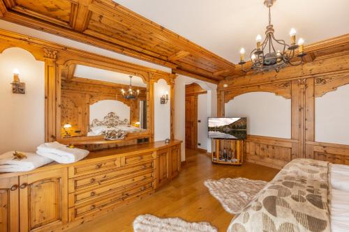 una camera da letto con pareti in legno e un grande specchio di Chalet Mountain Plaza - Apt Overland a Pinzolo