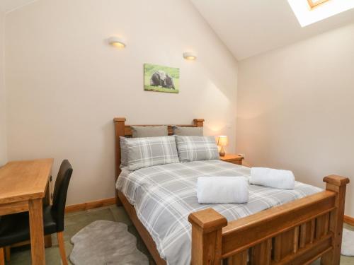 1 dormitorio con cama, escritorio y mesa en Shepherds Retreat, en Ashbourne