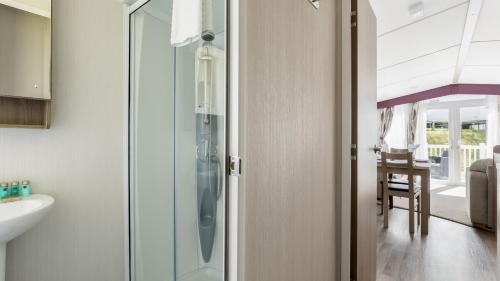 La salle de bains est pourvue d'un lavabo et d'une porte de douche en verre. dans l'établissement Hotel du Van, à Poole