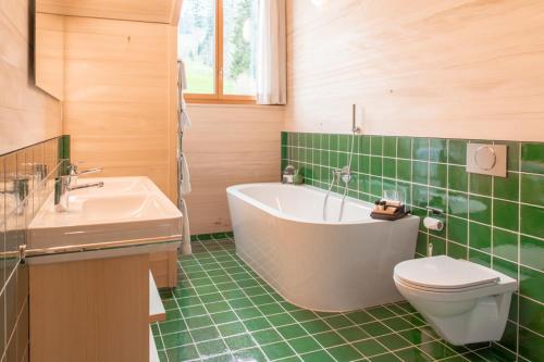 y baño con bañera, aseo y lavamanos. en Hotel Gasthaus Hergiswald, en Eigenthal
