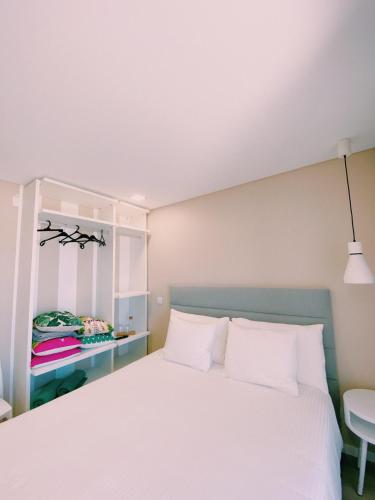 a bedroom with a white bed and a window at Maré Viva Bed & Breakfast in Rego da Leirosa
