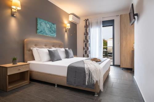 a bedroom with a large bed and a balcony at Eolica Rooms in Sarti