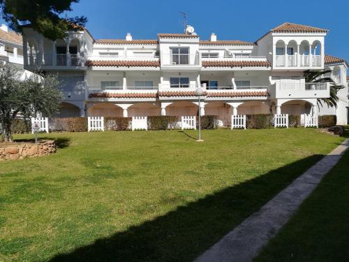 un gran edificio blanco con un gran patio en APCOSTAS - Complejo Al Andalus, en Alcossebre