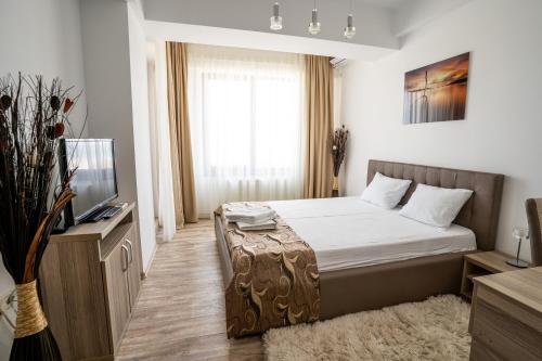 Habitación de hotel con cama y TV en Summerland Sea-View Luxury Apartment, en Mamaia