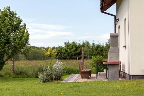 a patio with a table and a chair in a field at Dom Wakacyjny Kurnik by Renters in Kołczewo