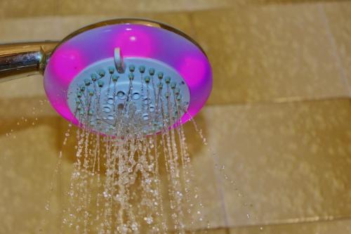 a pink shower head with water pouring from it at Affittacamere Il Veliero in Duino