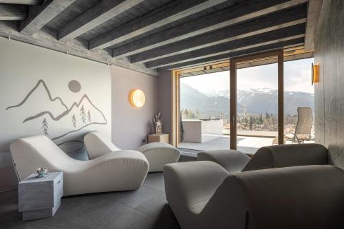 ein Wohnzimmer mit Sofas und Bergblick in der Unterkunft Hotel Bellavista in Cavalese