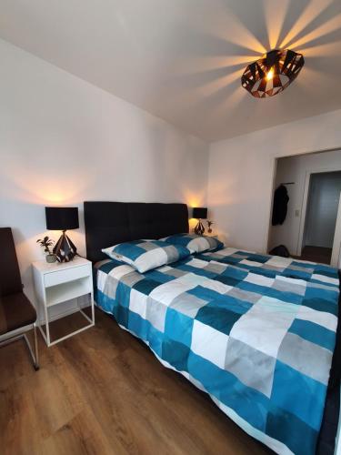 ein Schlafzimmer mit einem blauen und weißen Bett und einer Lampe in der Unterkunft Ferienwohnung Ruske in Friedrichshafen