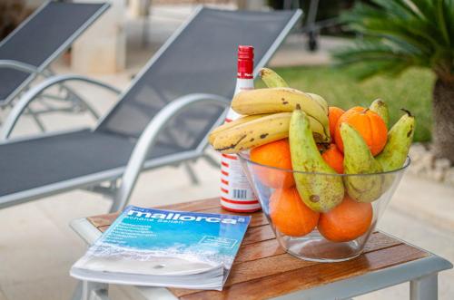 a bowl of fruit on a table with a bottle of beer at YourHouse Can Cuixa Villa in Can Picafort