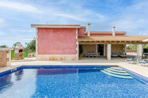 a swimming pool in front of a house at YourHouse Can Cuixa Villa in Can Picafort