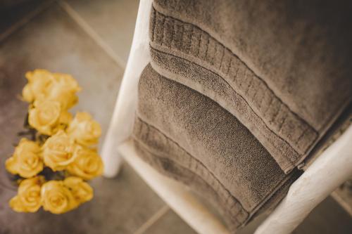 a pile of folded towels with yellow flowers at Relais Almaranto in Calamandrana