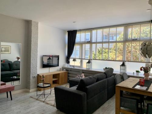 un soggiorno con divano e una grande finestra di Amsterdam Beach Apartment 2, Private Garden a Zandvoort