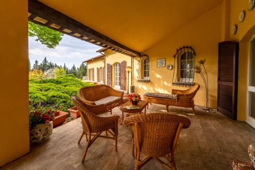 a patio with chairs and a couch and a table at Villa Sara in Foligno
