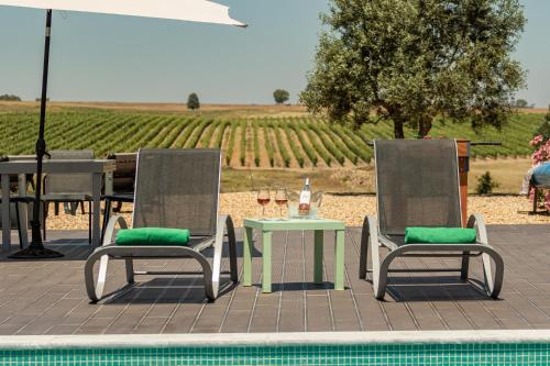 a table and two chairs and a table with a table and a table at Fontes Bárbaras Enoturismo in Entradas
