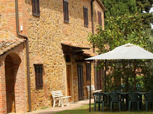 una mesa con sombrilla frente a un edificio en Da TILLI alla Fornace - Agriturismo, en Montaione