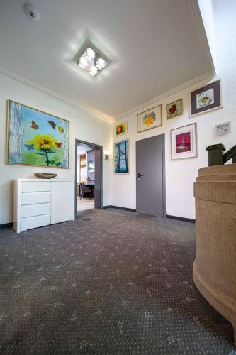 an empty room with a hallway with paintings on the walls at Parkhotel Plauen in Plauen