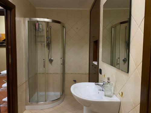 La salle de bains est pourvue d'une douche en verre et d'un lavabo. dans l'établissement Home in love: vicoletto dei presepi, à Naples
