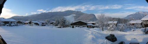 ein schneebedecktes Dorf mit Häusern und Bergen in der Unterkunft Haus Wendelweg in Unterwössen