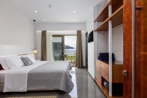 a bedroom with a large bed and a balcony at Elsa Exclusive Double Sea View - Adults Only in Plakias