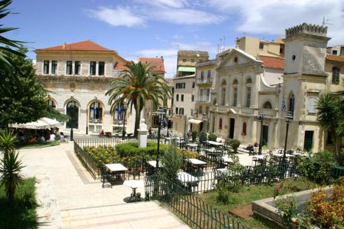 a group of buildings with tables and chairs at Gardelis Gardens in Benitses