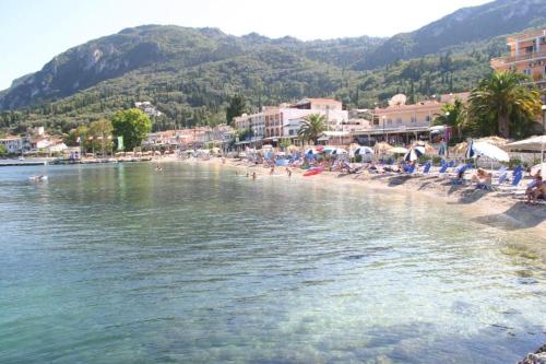 a group of people on a beach near the water at Gardelis Gardens in Benitses