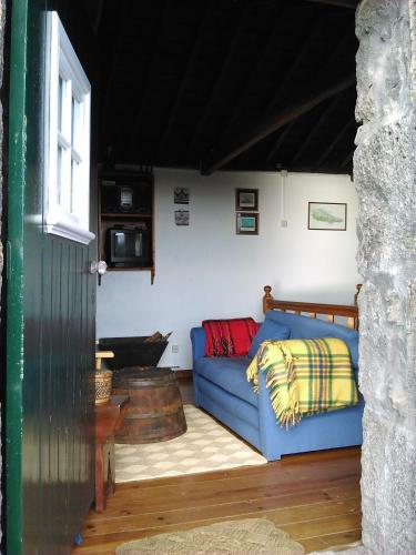 a living room with a blue couch in a room at Casa da Adega in Prainha de Baixo