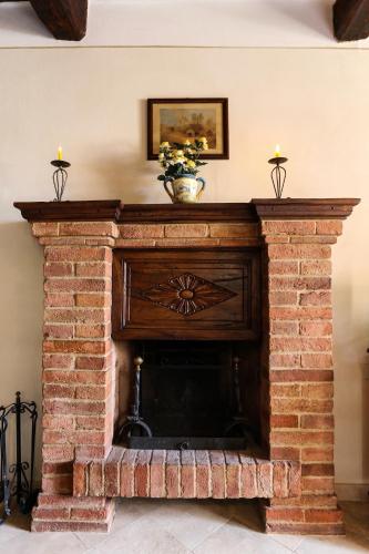 a brick fireplace with a vase on top of it at Il Colle Rigomagno in Rigomagno
