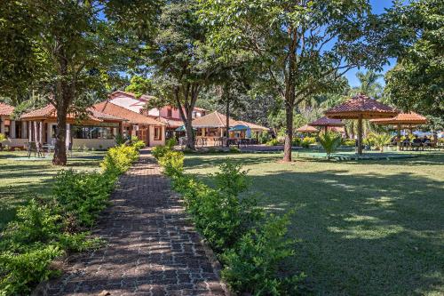 a brick path in a park with trees and buildings at Santa Eliza Eco Resort in Ribeirão Bonito