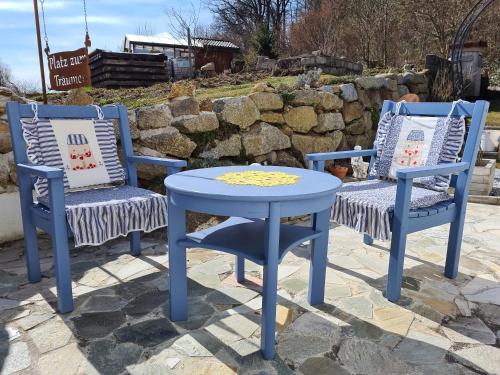 two blue chairs and a table and a table and chairs at Burgi`s Ferienhaus in Litschau