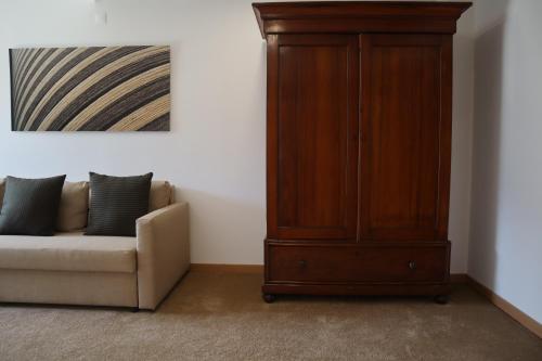 a living room with a couch and a wooden cabinet at Hotel da Fábrica in Manteigas