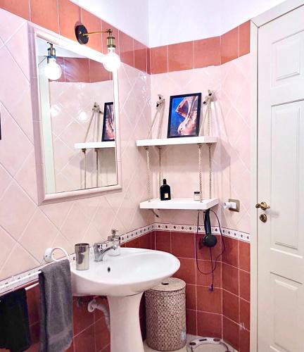 a bathroom with a sink and a mirror at Marina Design Apartment in Marina di Ragusa