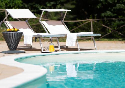 two chairs sitting next to a swimming pool at Castello di Baccaresca in Branca