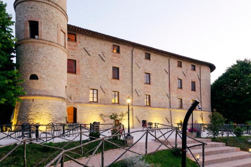 a large brick building with a clock tower at Castello di Baccaresca in Branca