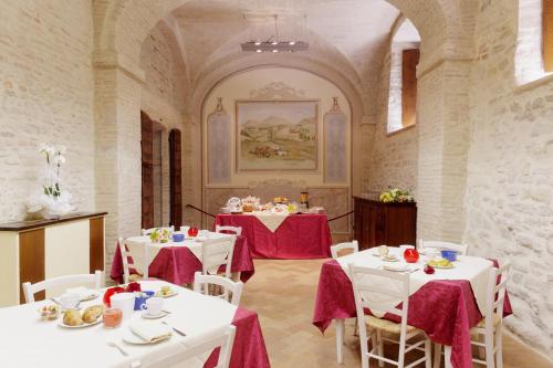 a dining room with white tables and white chairs at Castello di Baccaresca in Branca