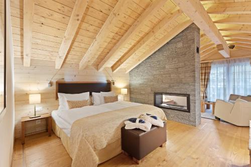 a bedroom with a large bed and a fireplace at Grand Hotel Zermatterhof in Zermatt