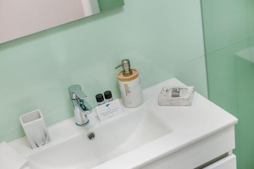 W łazience znajduje się biała umywalka i lustro. w obiekcie Espinho Beach 4 Stays w mieście Espinho